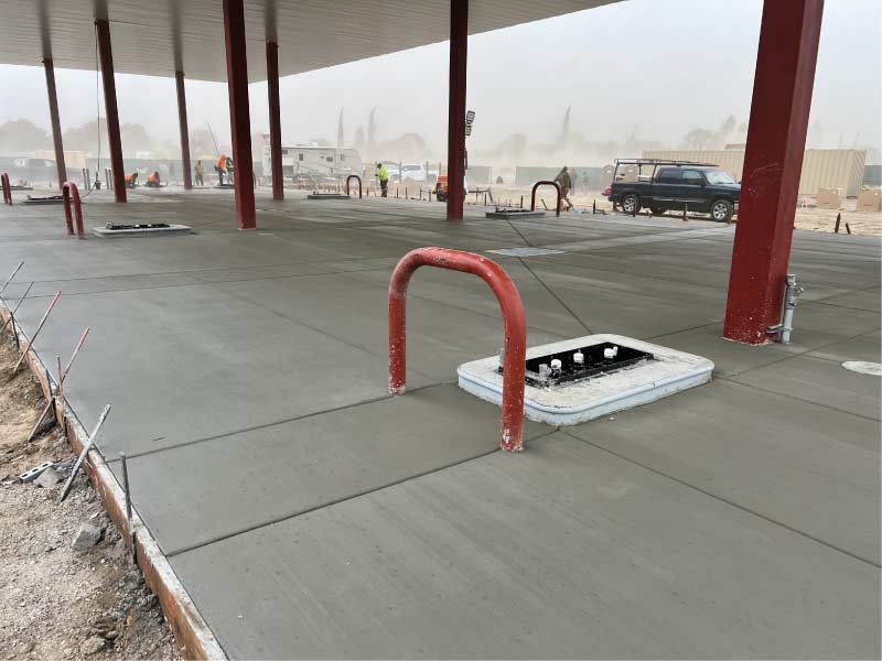 Large-scale structural concrete slab installation for a commercial building foundation featuring expert formwork and integrated utility access points.