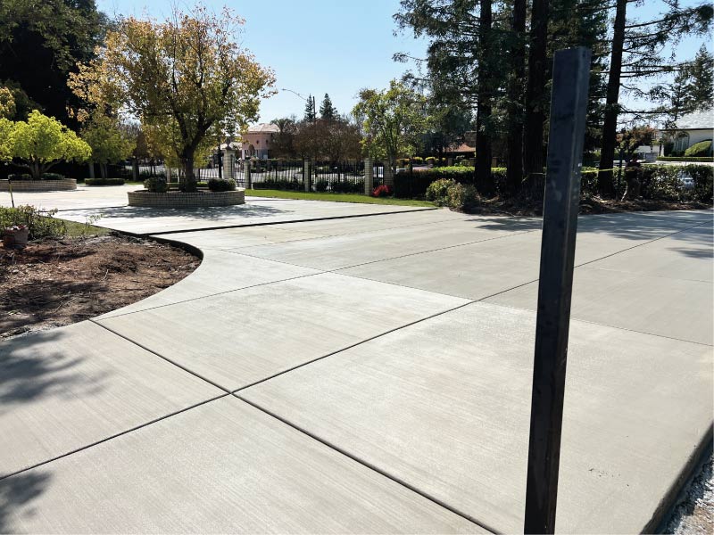 A wide, freshly poured concrete walkway featuring clean broom finishes and precise control joints to ensure long-term durability and slip resistance for a commercial property
